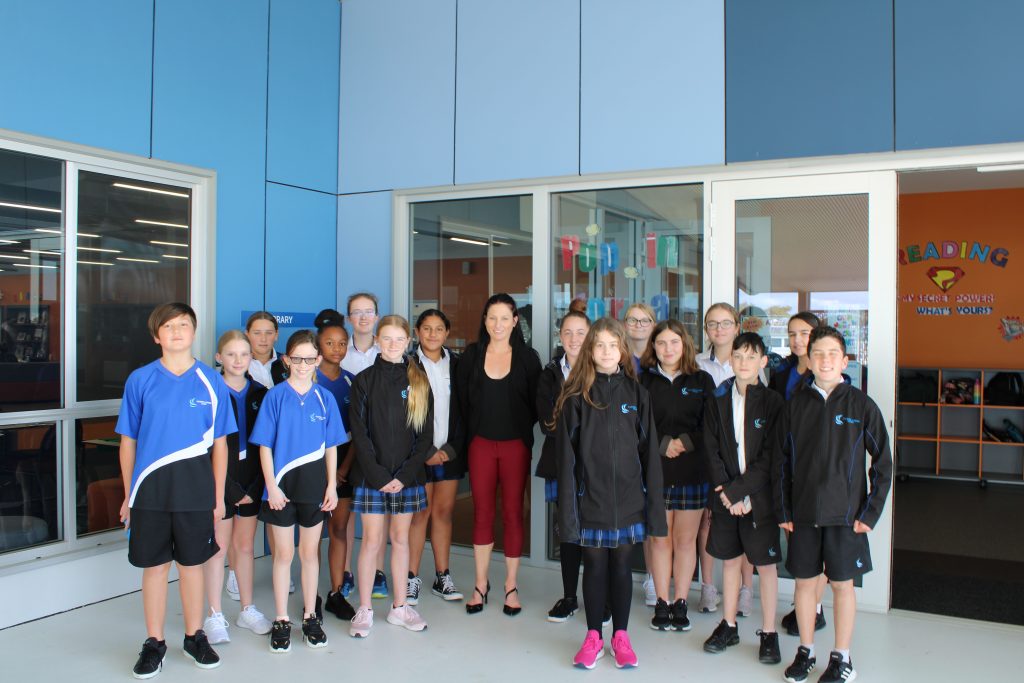 Student Leaders, Peer Supporters and House Captains standing with Ms Romagnolo outside of the Library