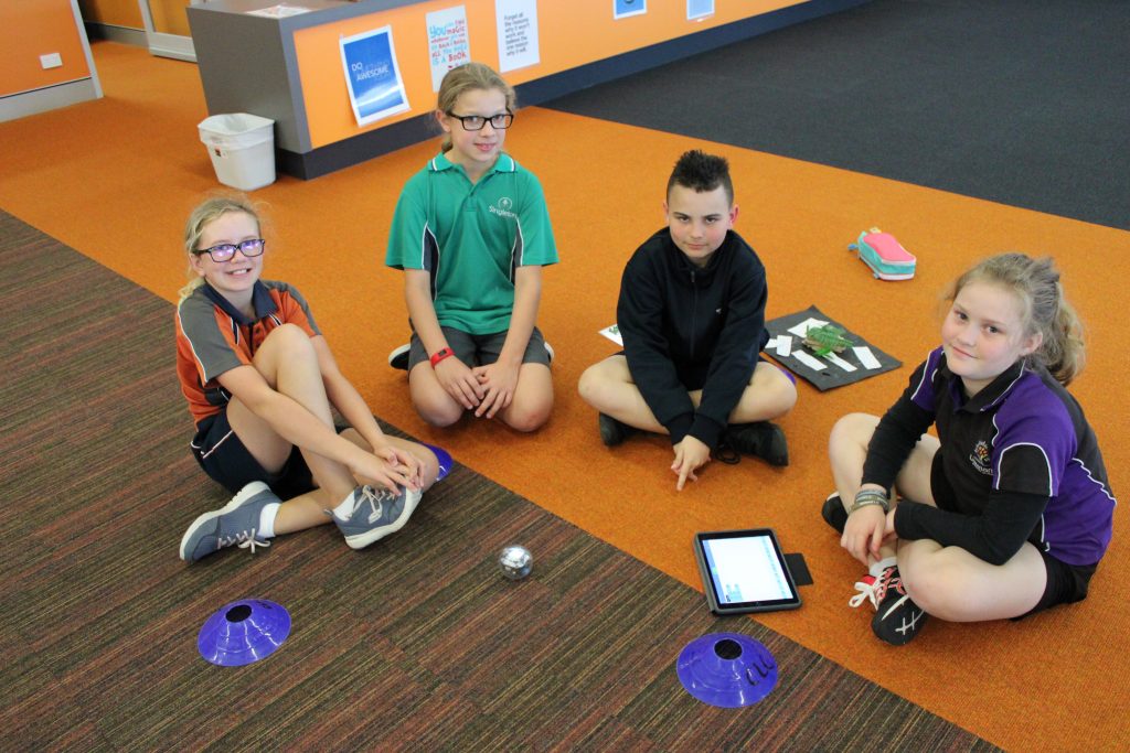 4 local primary school students playing with Spheros